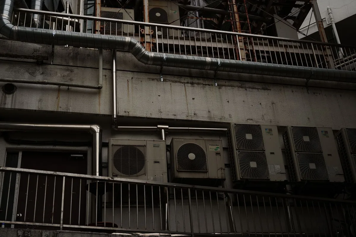 Outdoor mini split condenser units mounted outside a building with wall-mounted refrigerant lines